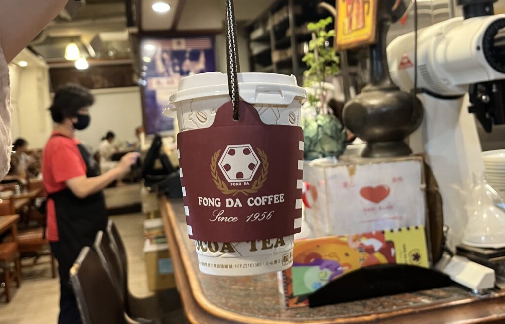 ラテお持ち帰りの様子。
紙のカップのスリーブに紐が付いていて便利。